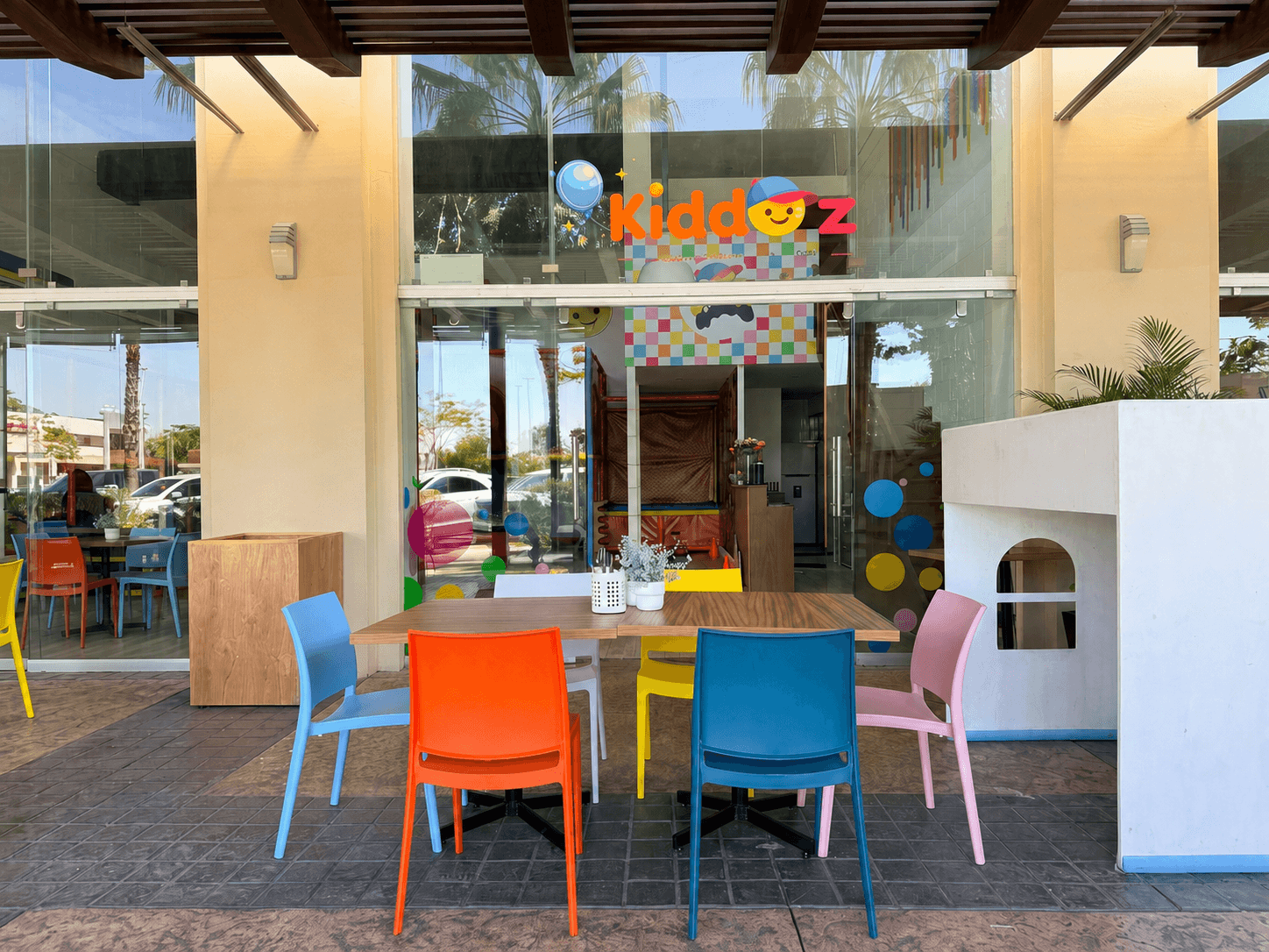 Adultos disfrutando en la terraza de Kiddoz con bebidas y aperitivos